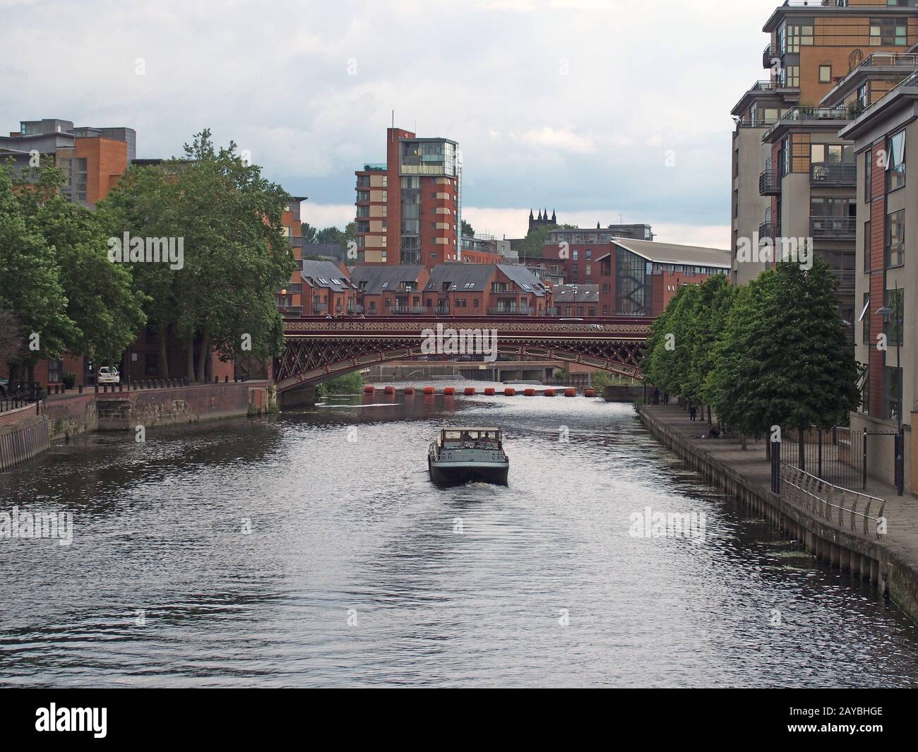 a boat sailing along the river aire in leeds towards crown point bridge and the city centre Stock Photo