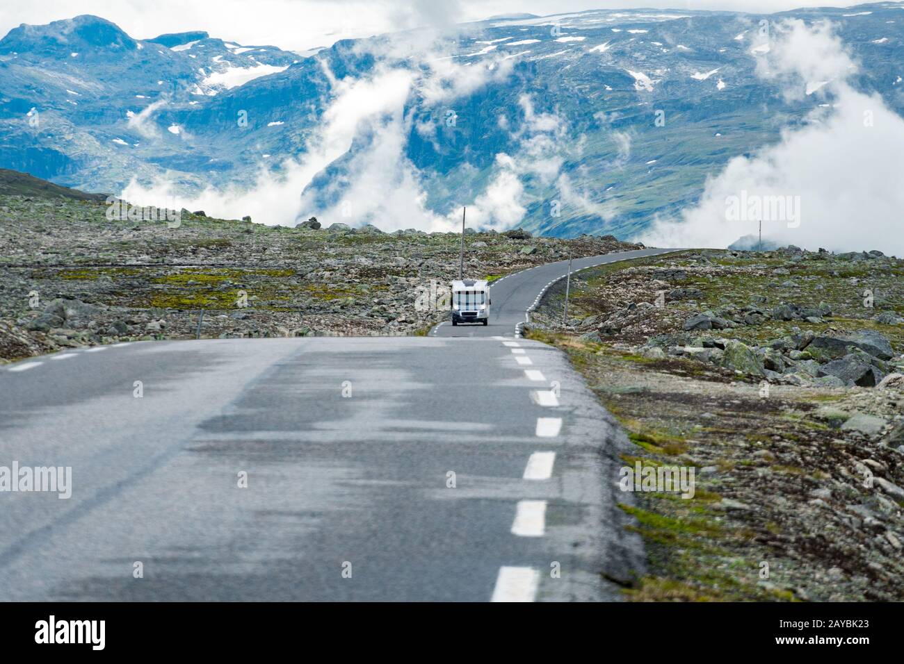 Camper car in norwegian mountains. Tourism vacation and travel. Caravan car RV travels on the mountain road, pass Norway. Scandi Stock Photo