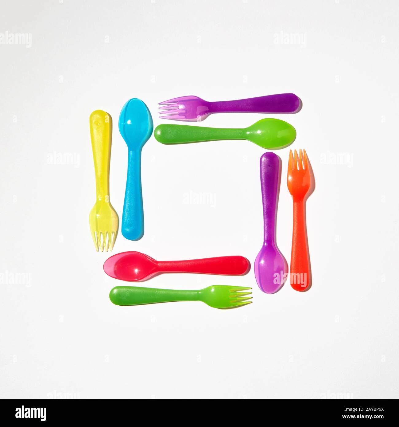Square from colorful plastic cutlery on a light background. Stock Photo