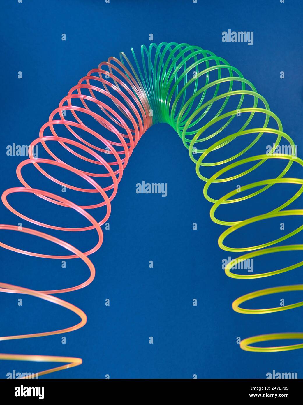 Stretching slinky toy in the shape of parabola. Stock Photo