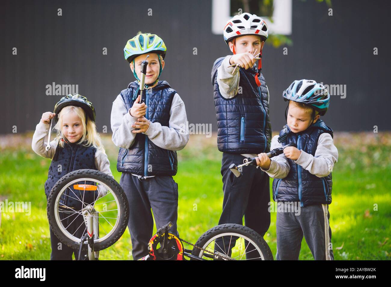 Children mechanics, bicycle repair. Happy kids fixing bike together