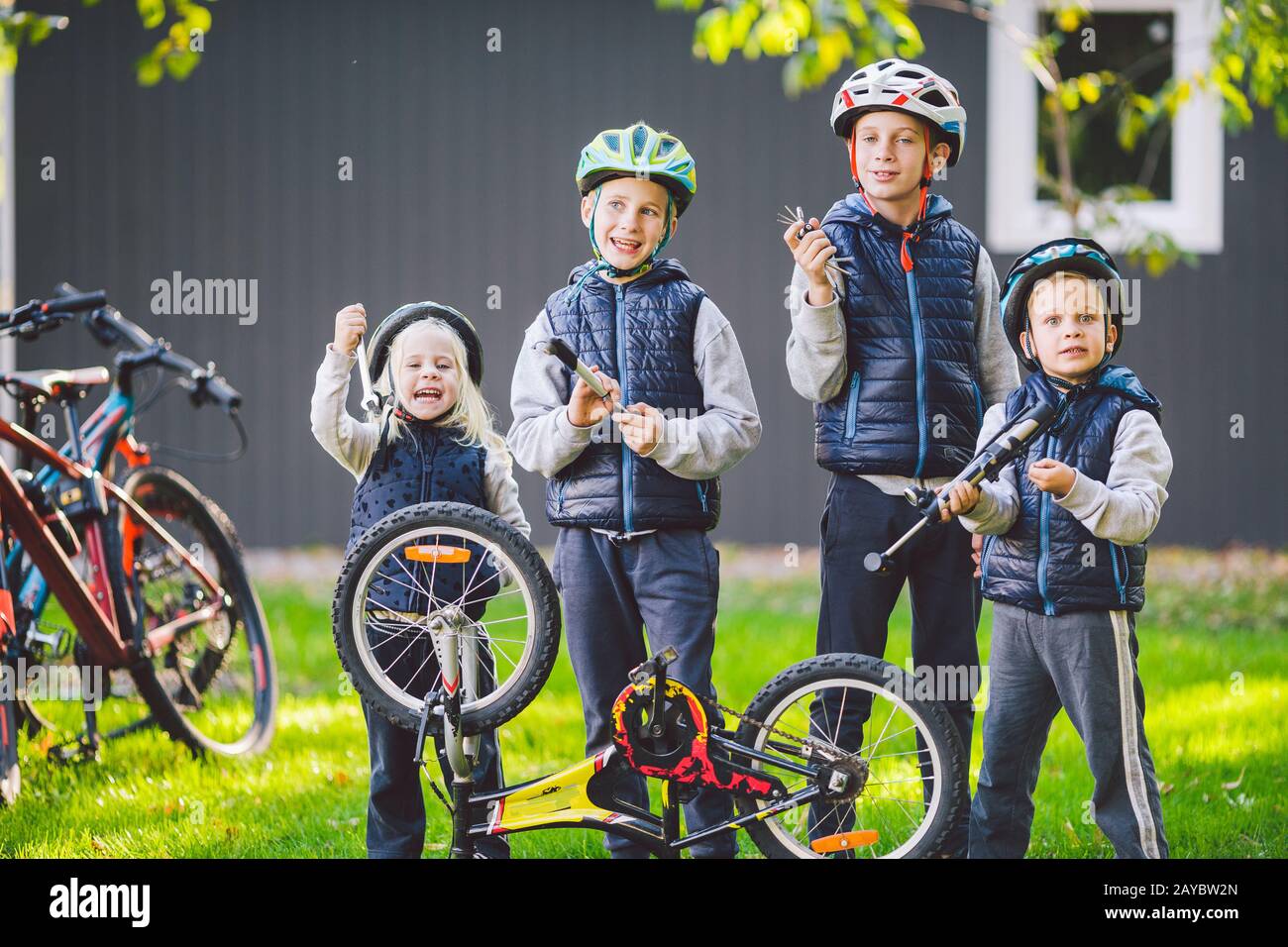 Children mechanics, bicycle repair. Happy kids fixing bike together