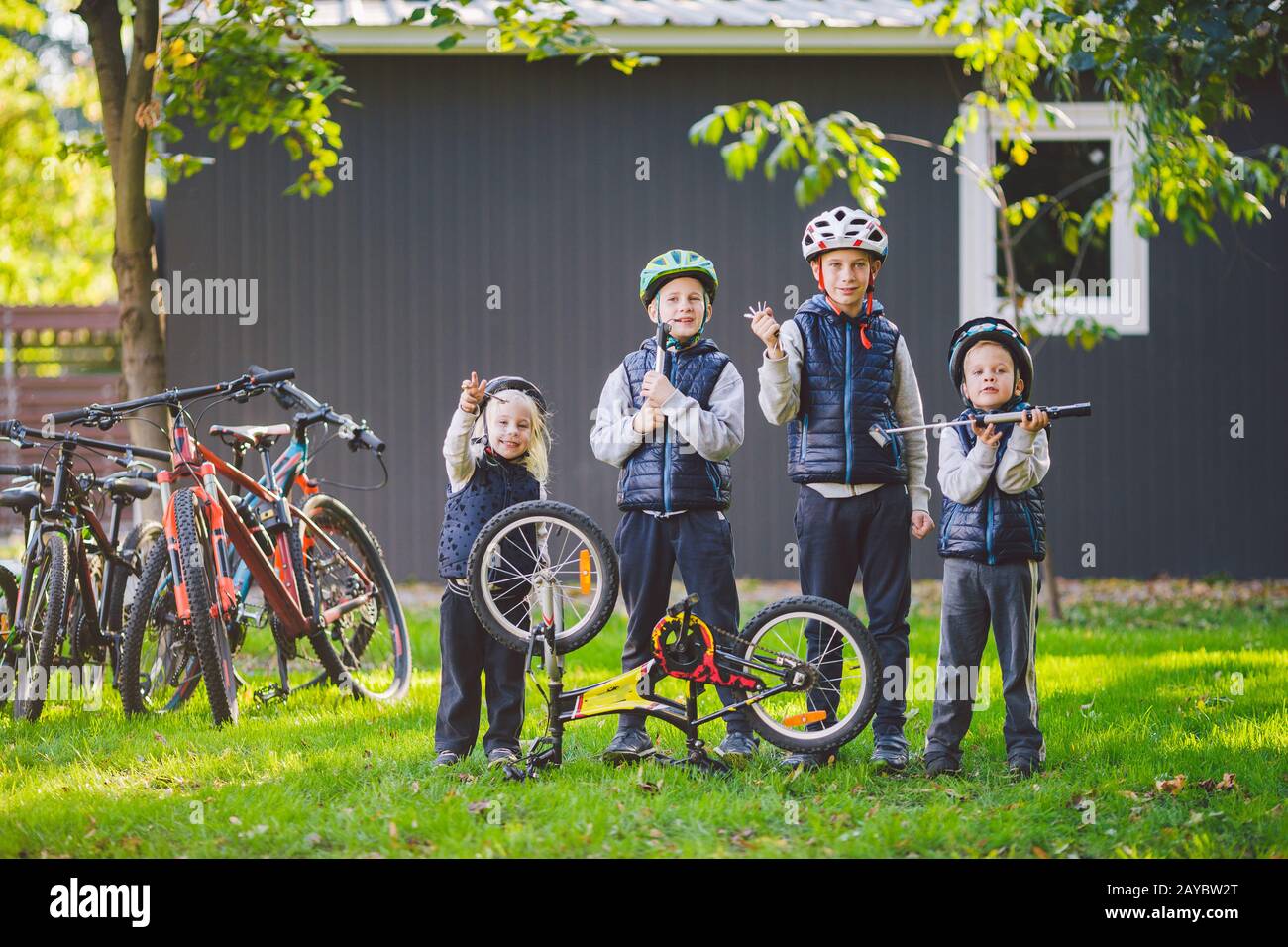 Children mechanics, bicycle repair. Happy kids fixing bike together