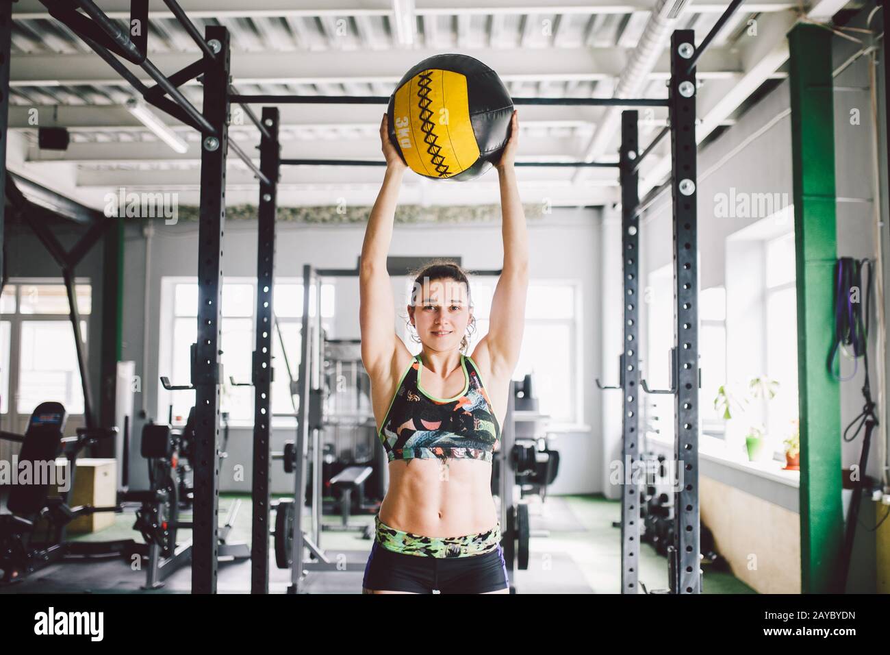 beautiful caucasian girl holding a ball in the gym. Dressed in top and shorts Stock Photo