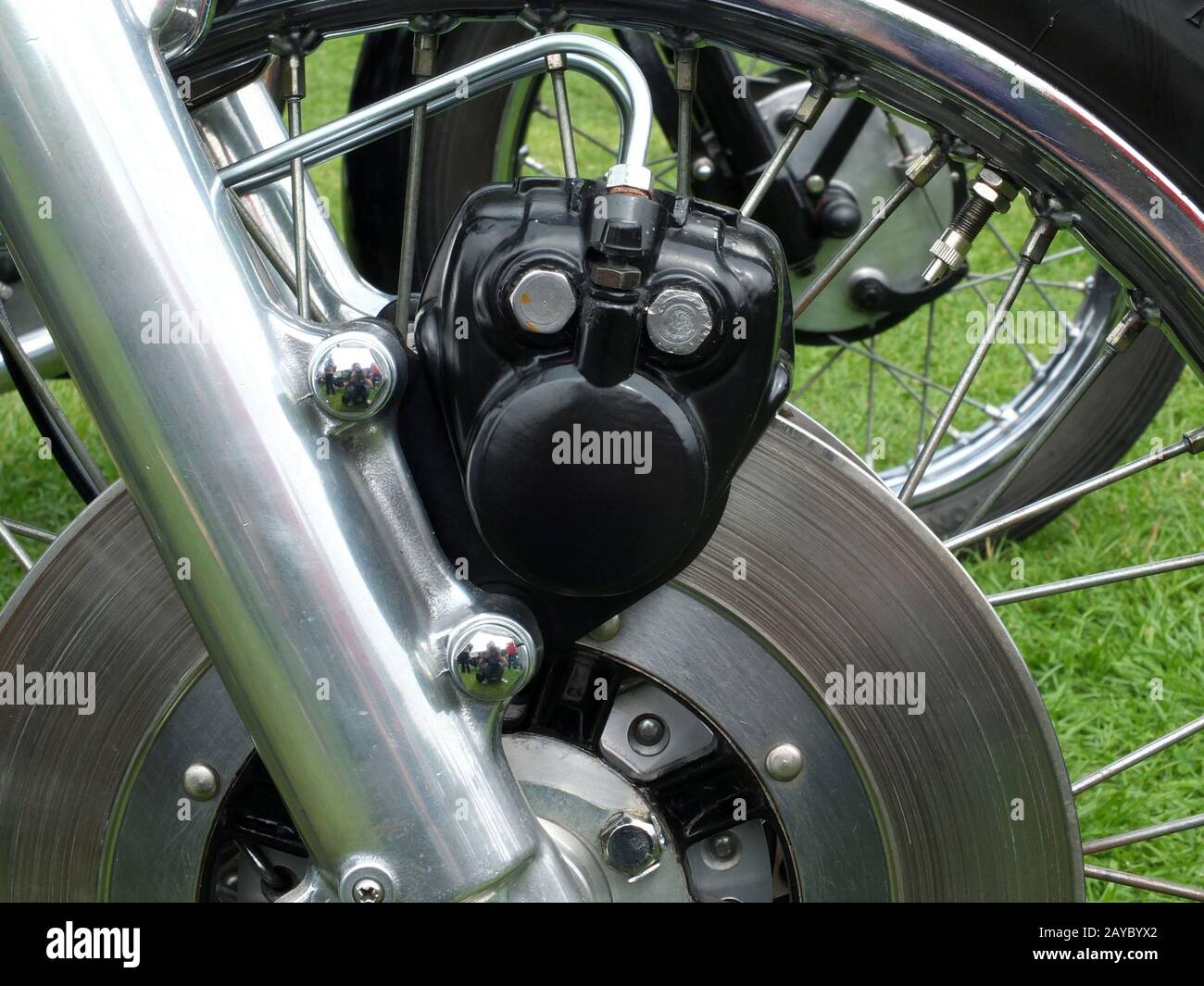 close up of a metal disk brake on the front wheel of an old motorcycle