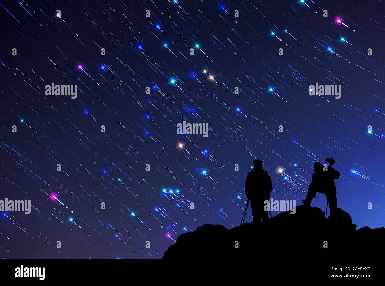Under the star trails in the sky, the silhouette of the photographer ...