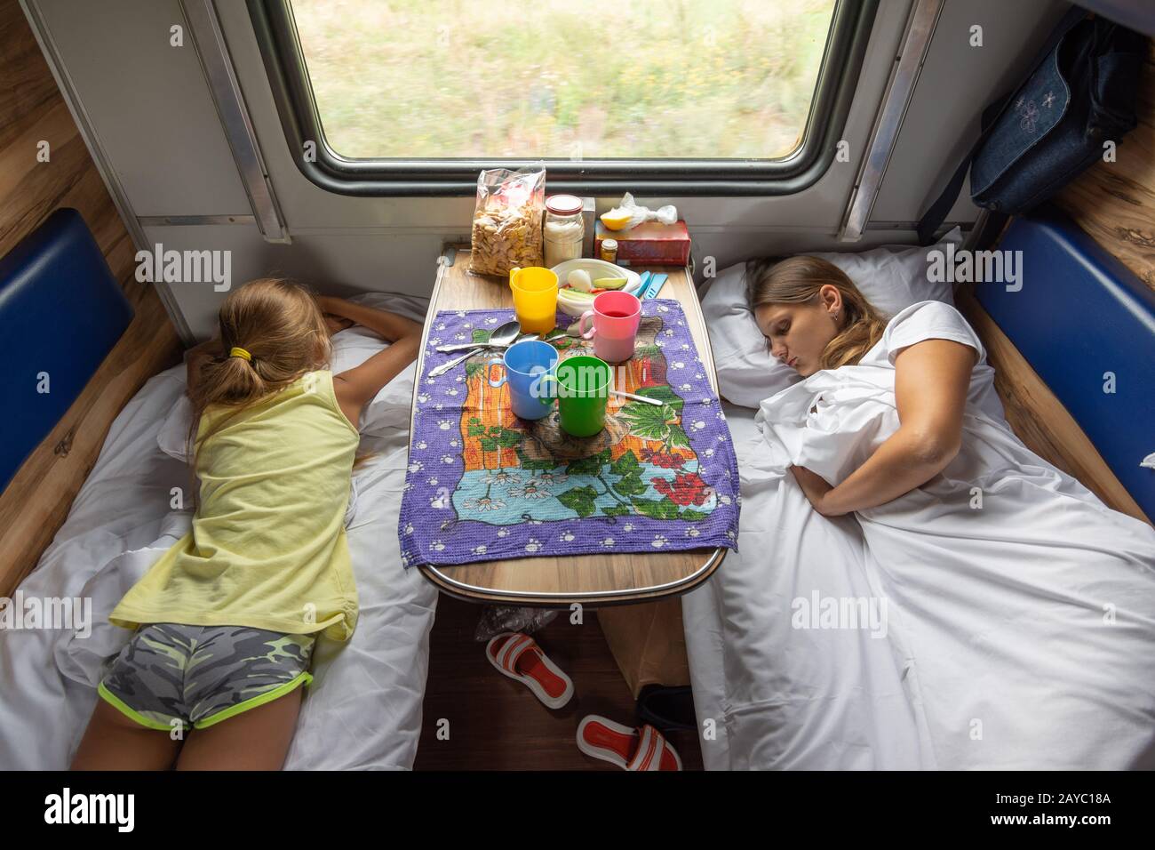 The situation on the train, mom and daughters are sleeping on the lower shelves in the car Stock Photo