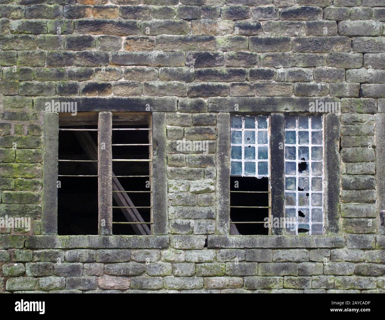 broken windows in an old derelict stone house Stock Photo