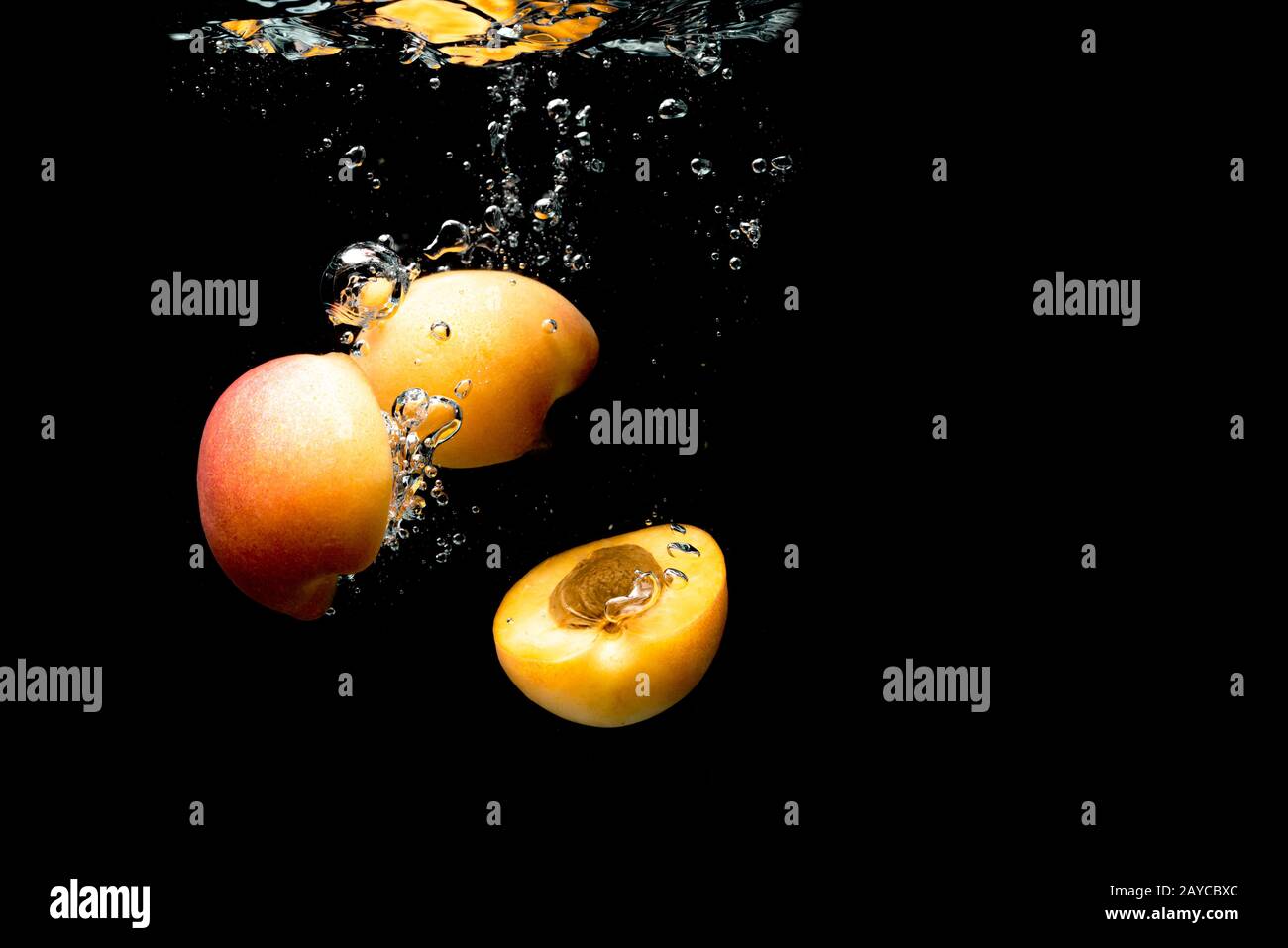 Fresh Nectarine with water splash over black background Stock Photo