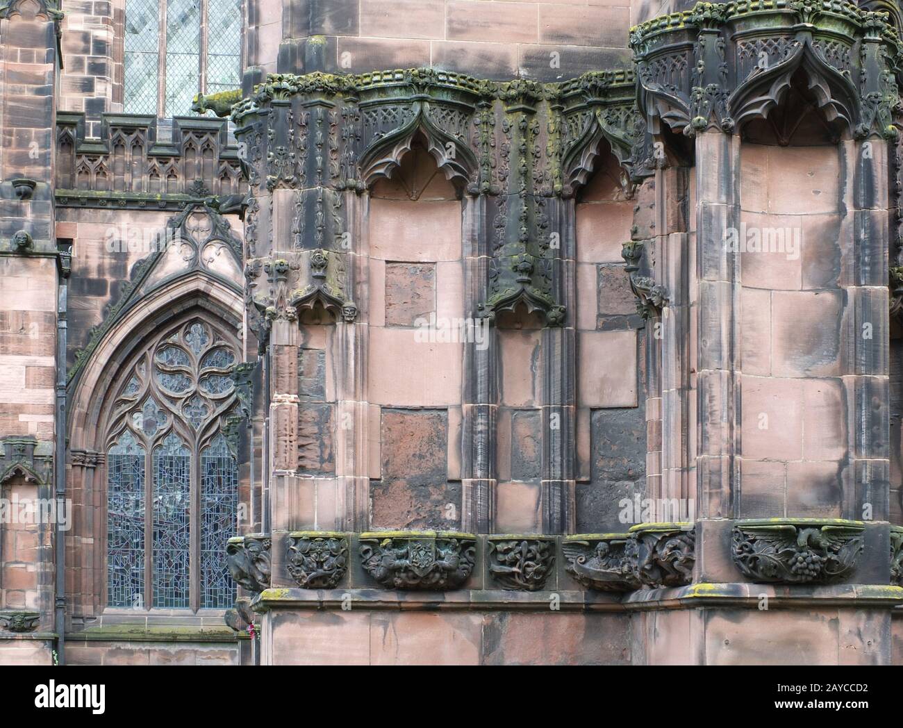 details of ornately carved medieval stonework with niches and faces on the facade of chester cathedral Stock Photo