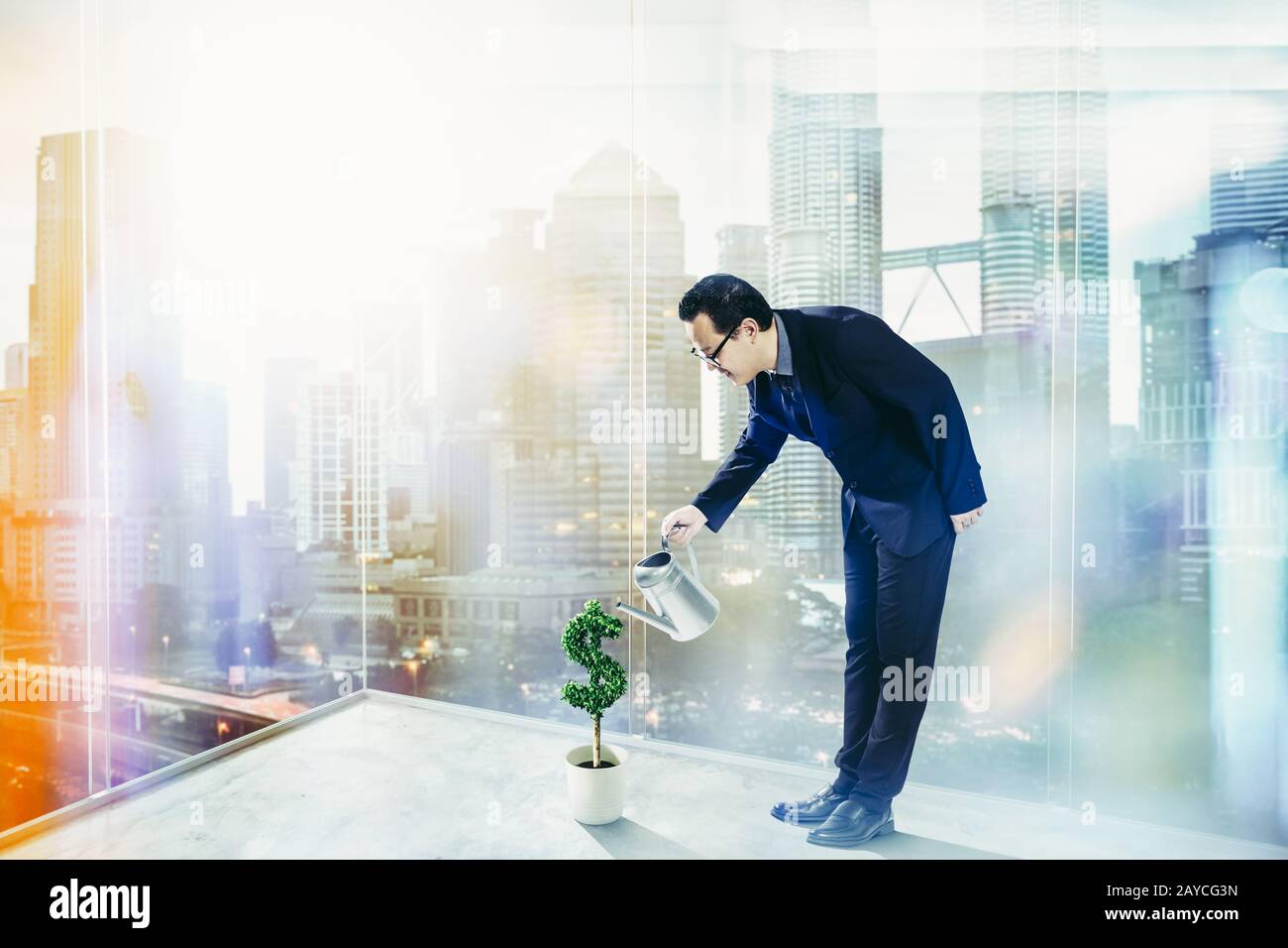 Business Man pouring water on dollar shaped tree . Business growth and entrepreneurship concept. Stock Photo