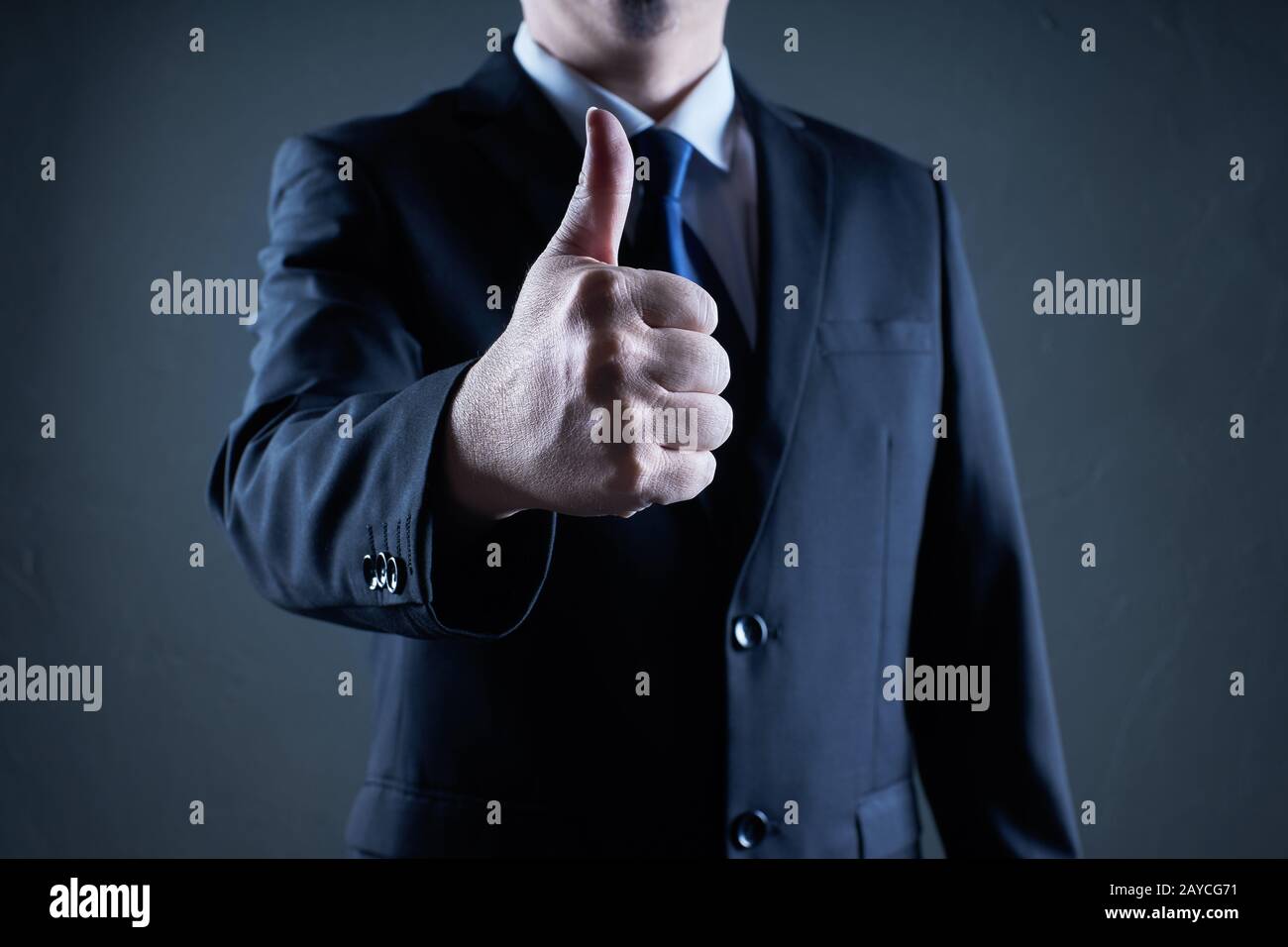 Successful businessman gives thumb up pose. Likes and positive feel. Gesture good and agree Stock Photo