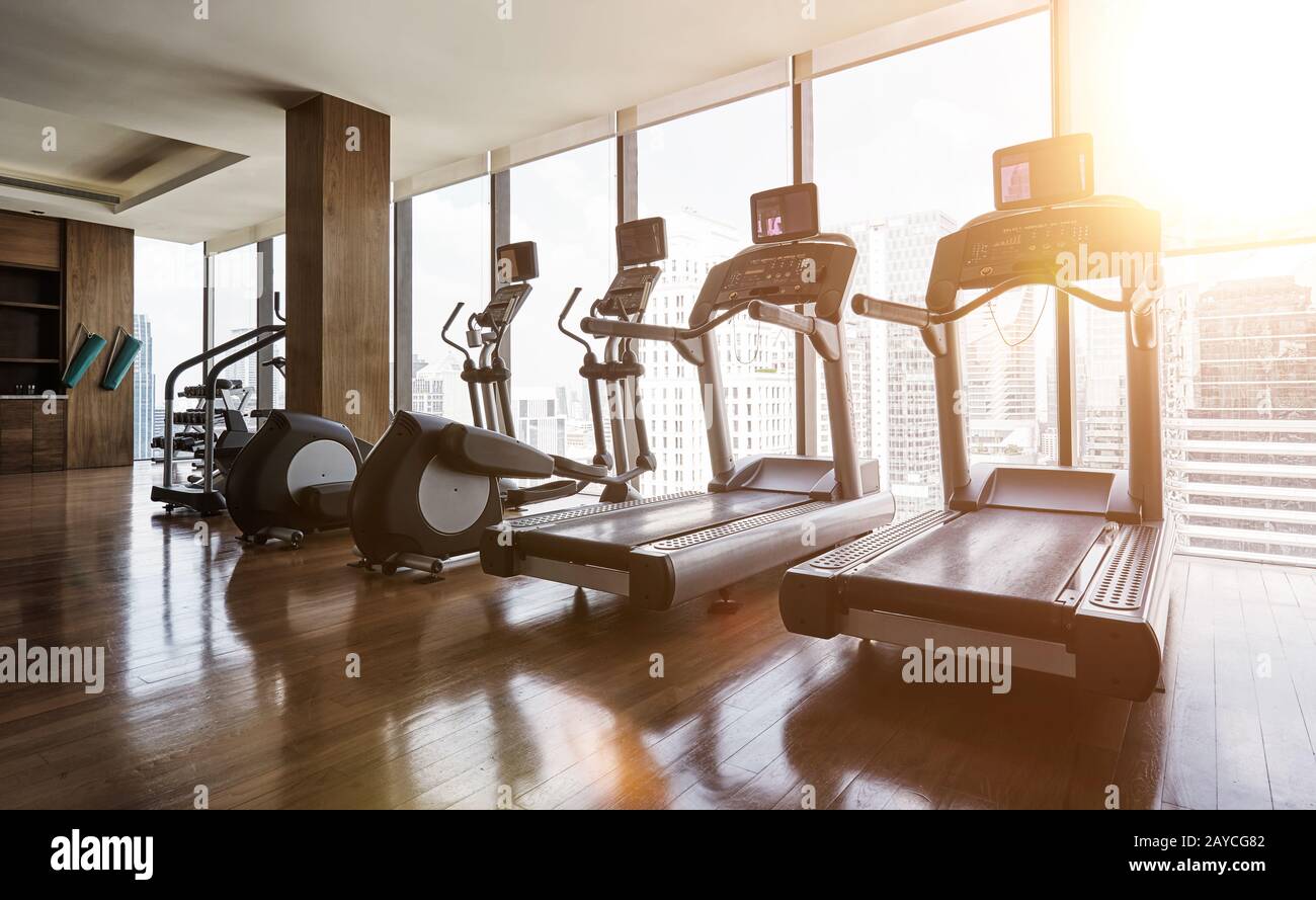 Modern gym room fitness center with set of treadmills staying in line Stock Photo
