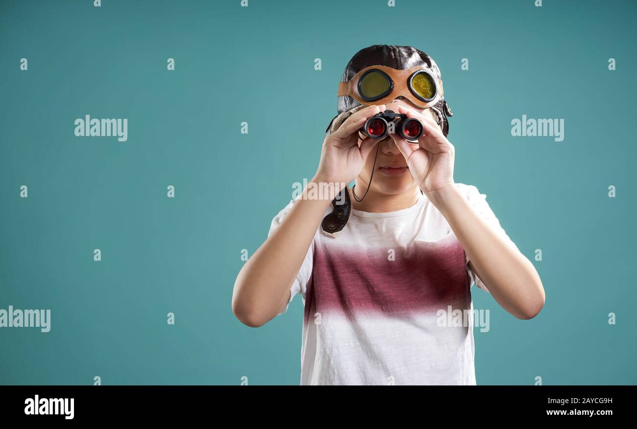 Smart kid using binoculars facing camera . Stock Photo