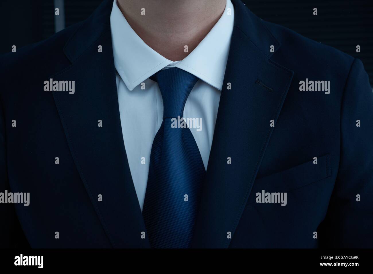 Part of man body side folded his arms in black suit on black background Stock Photo