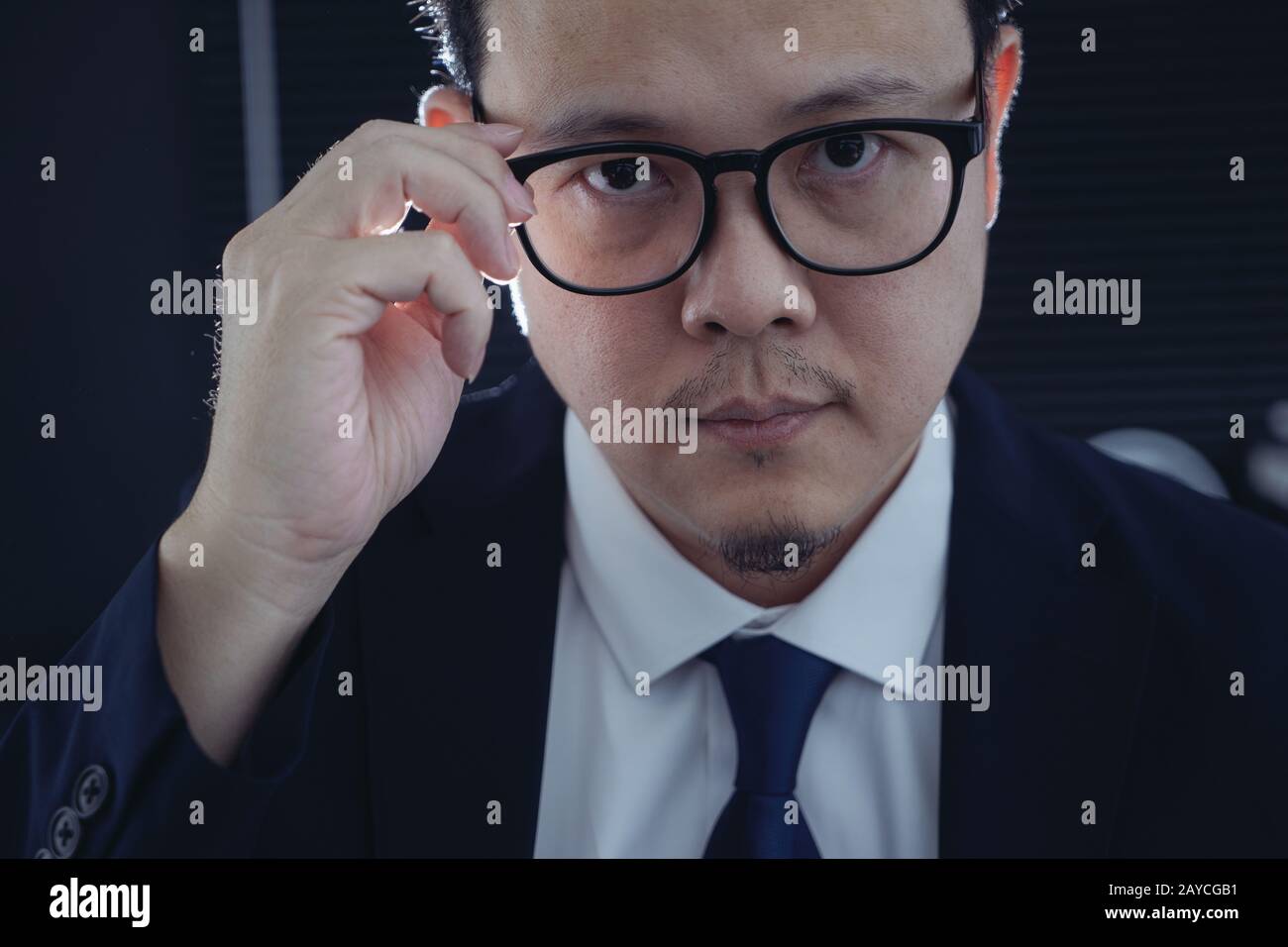 Smart businessman in suit and eyeglasses looking at camera . Closeup view . Stock Photo