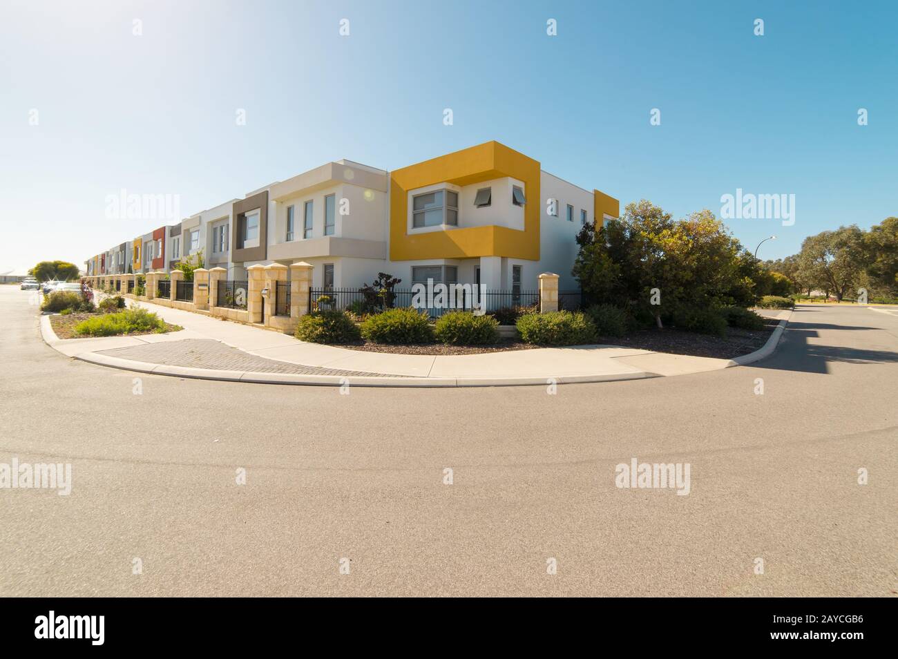 Asphalt road with modern terrace house in front on blue sky background. Yanchep Beach Town Stock Photo