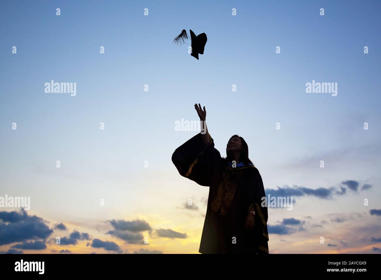 Silhouette Of Young Female Student Celebrating Graduation Stock Photo