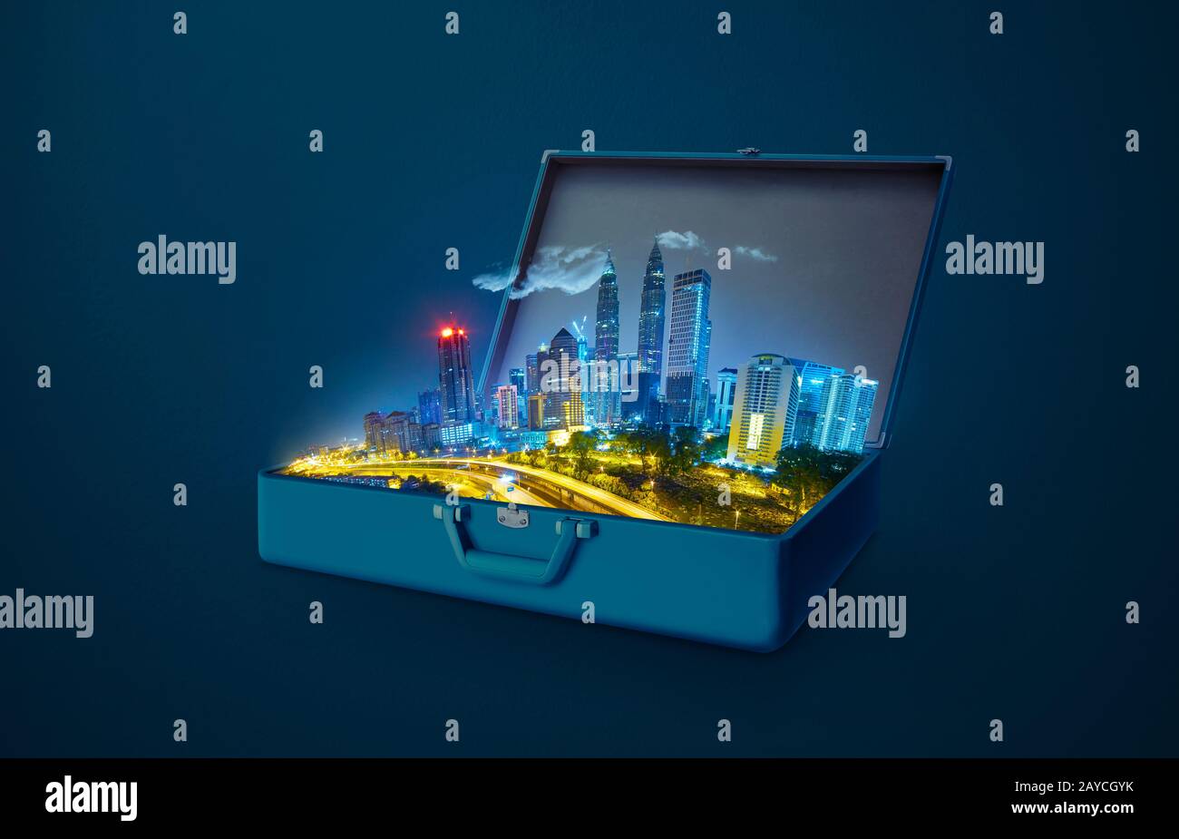 Night scene modern city skyscraper in an open retro vintage suitcase isolated on blue background . Stock Photo