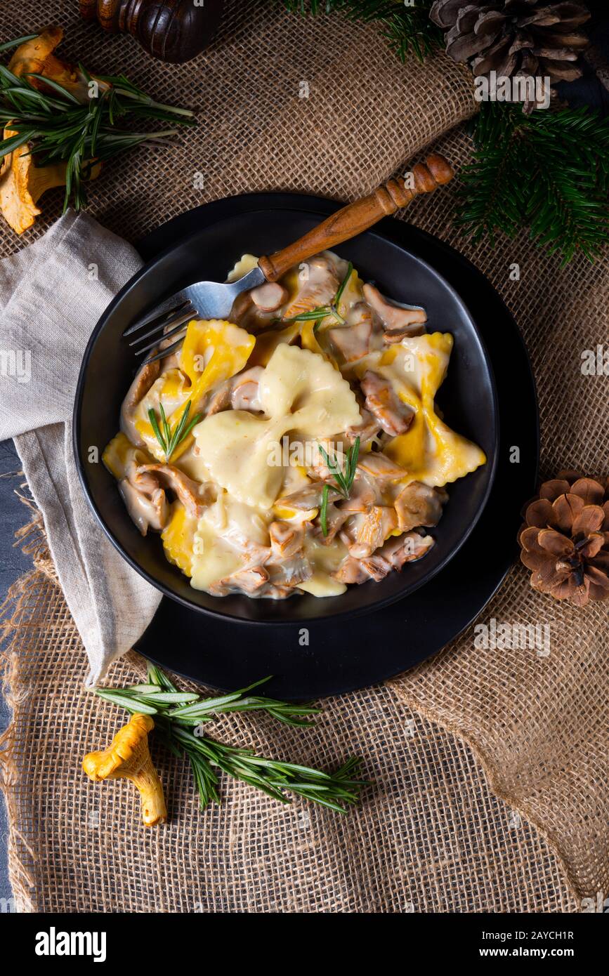 Colorful farfalle pasta with chanterelles and cream sauce Stock Photo