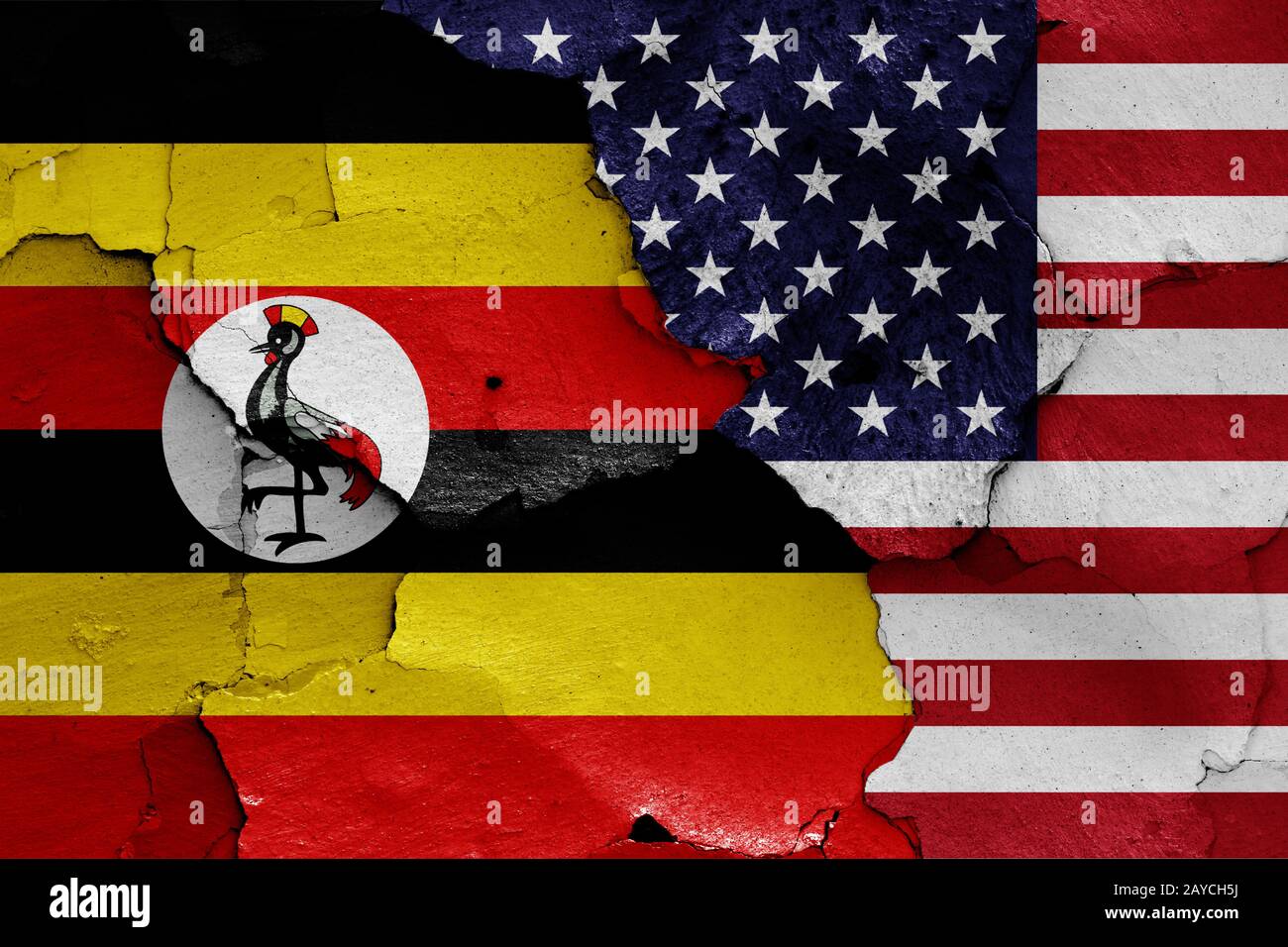 flags of Uganda and USA painted on cracked wall Stock Photo