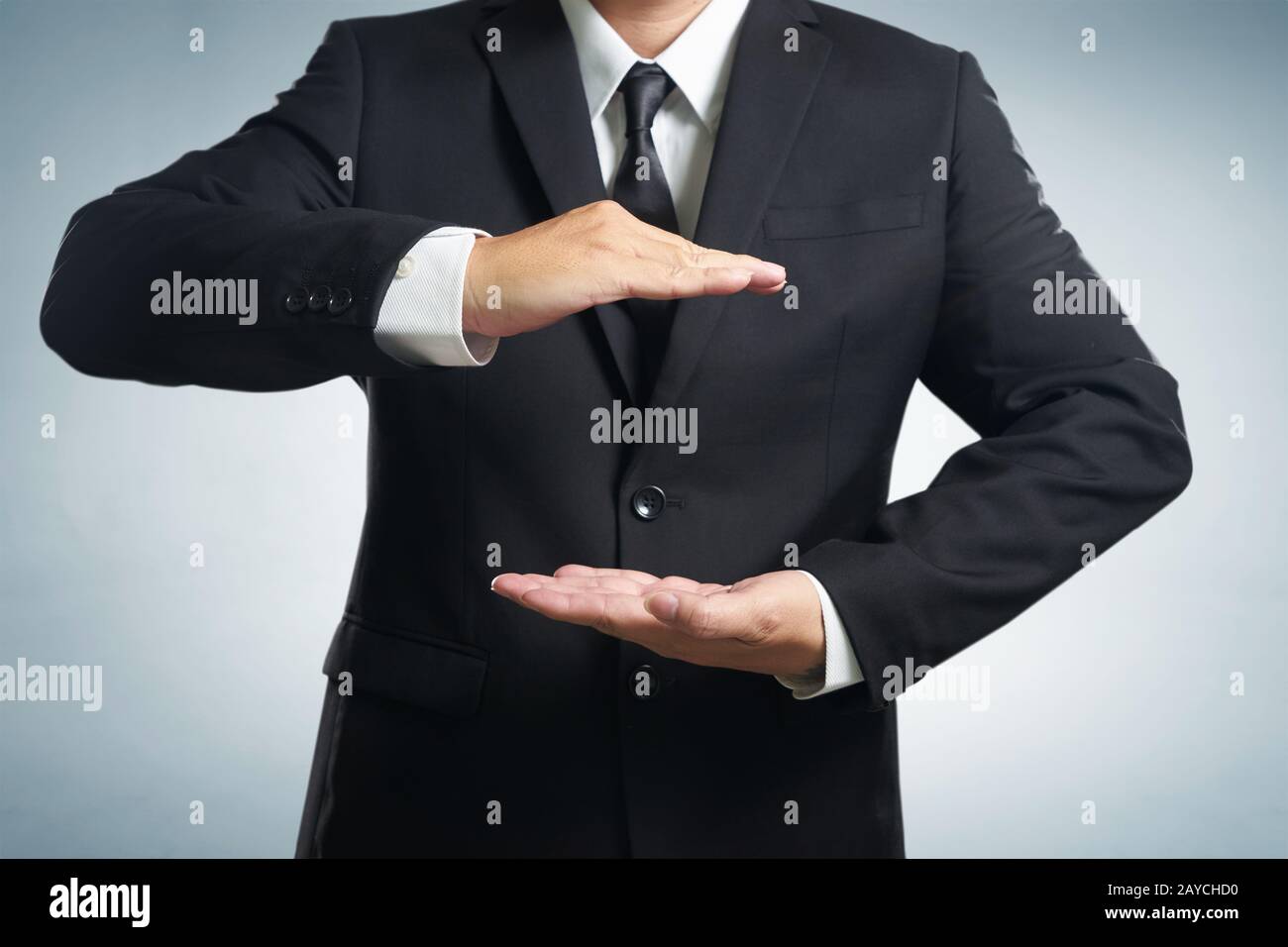 Businessman in suit with two hands in position to protect something (focus on hand Stock Photo