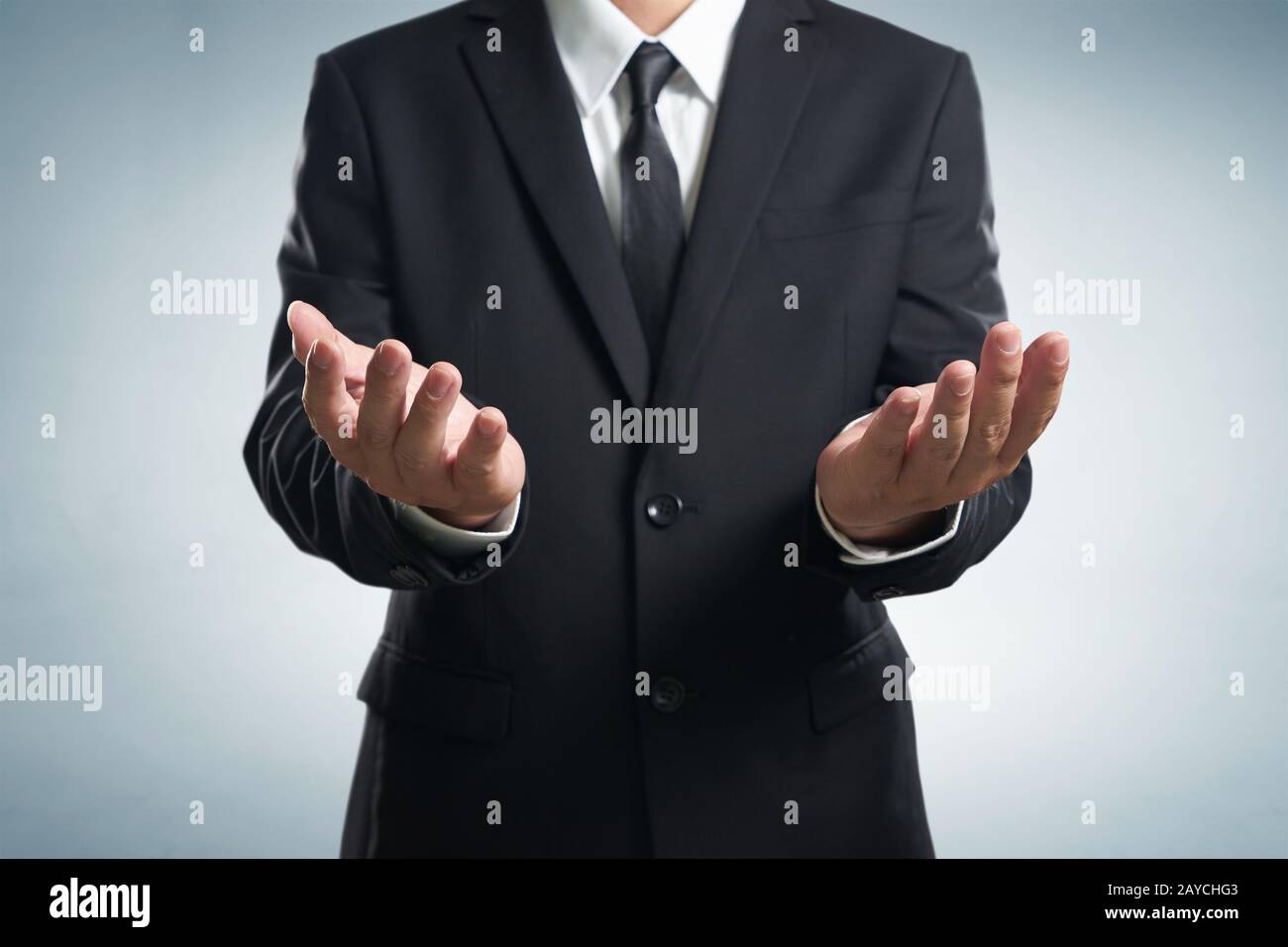Businessman  in black suit lending a helping hand Stock Photo
