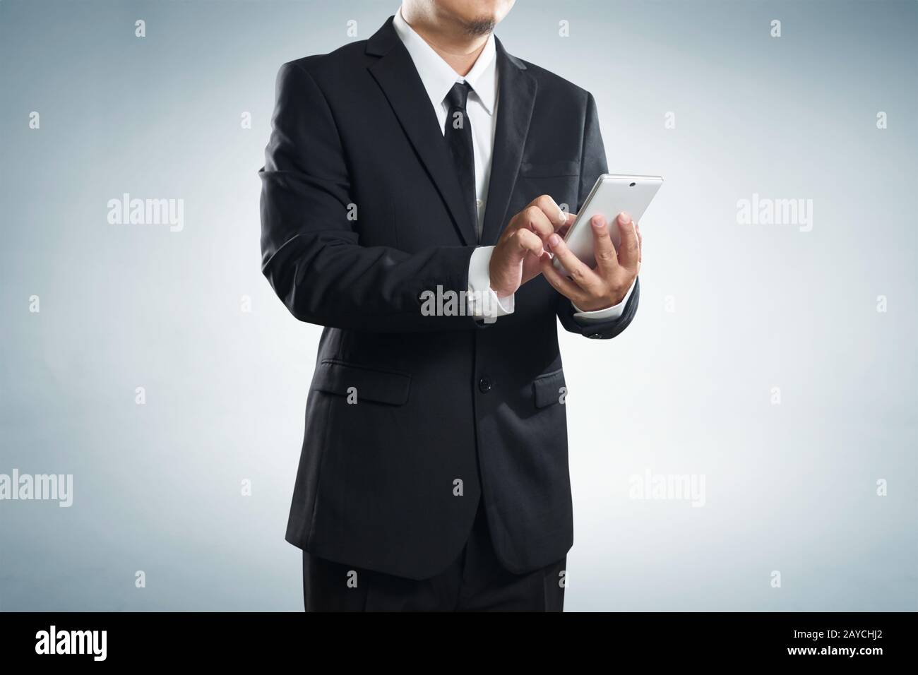 Corporate male executive messaging via phone Stock Photo