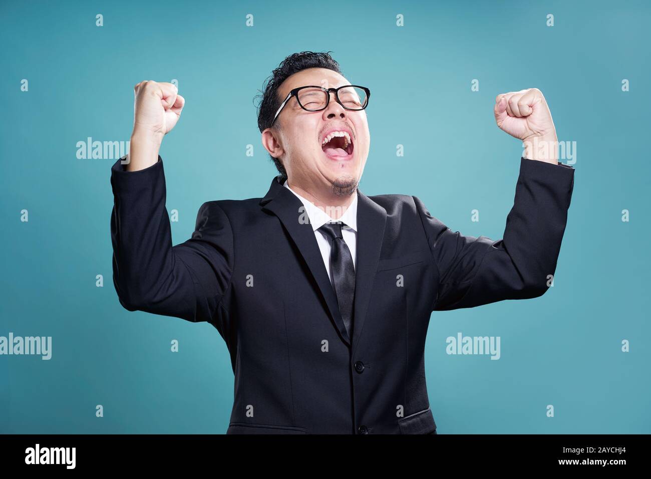 Excited businessman isolated on the cyan background . Stock Photo