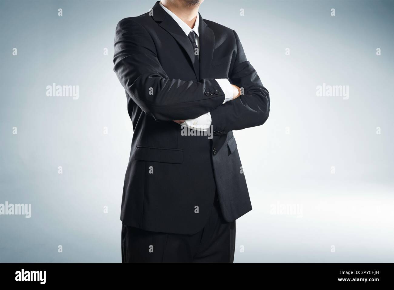 part of man body side folded his arms in black suit on white background Stock Photo