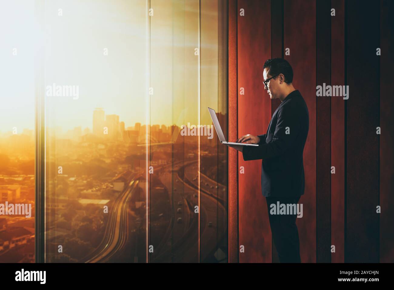 Businessman using laptop with generic office background Stock Photo