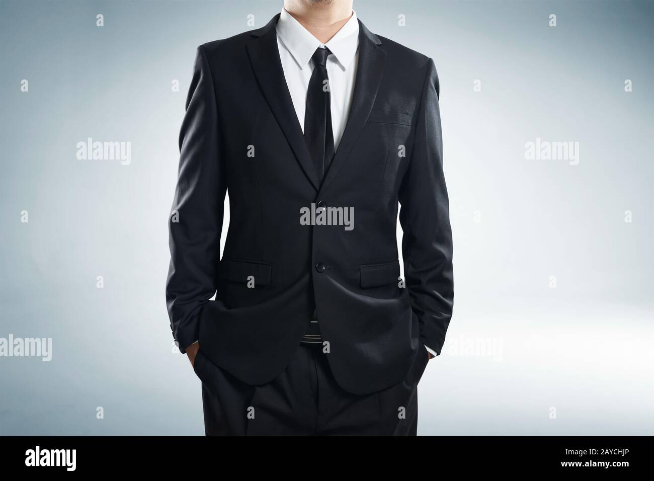 close up part of man body in black suit with hands in pockets on white background Stock Photo