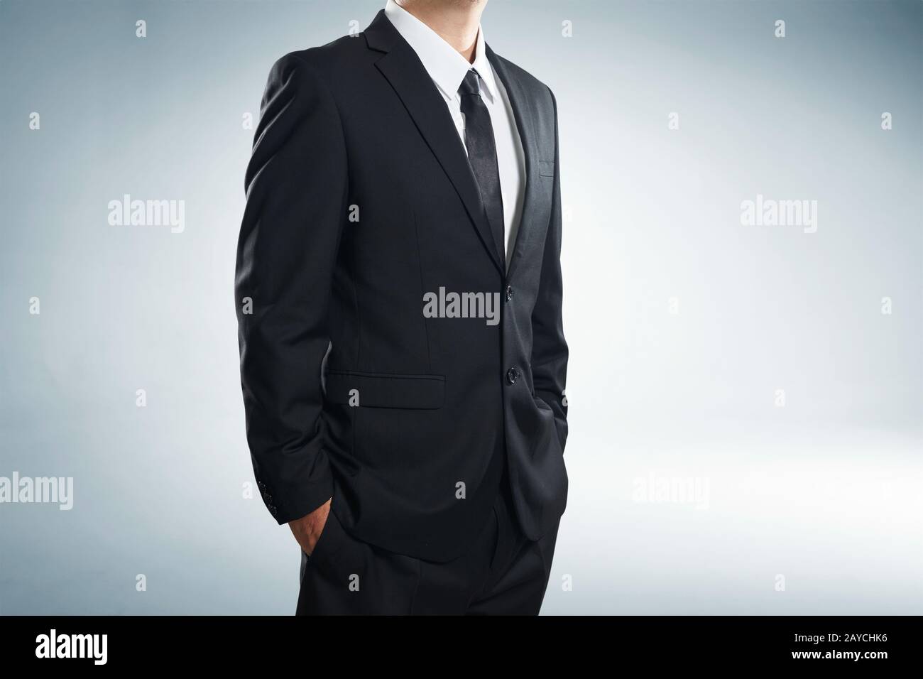 close up part of man body in black suit with hands in pockets on white background Stock Photo