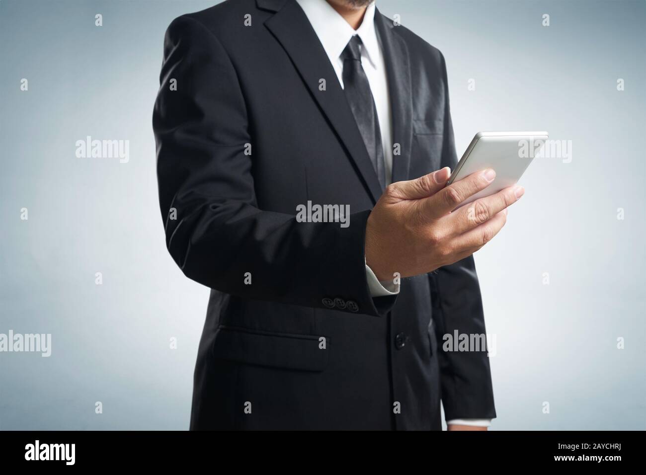 Corporate male executive messaging via phone Stock Photo