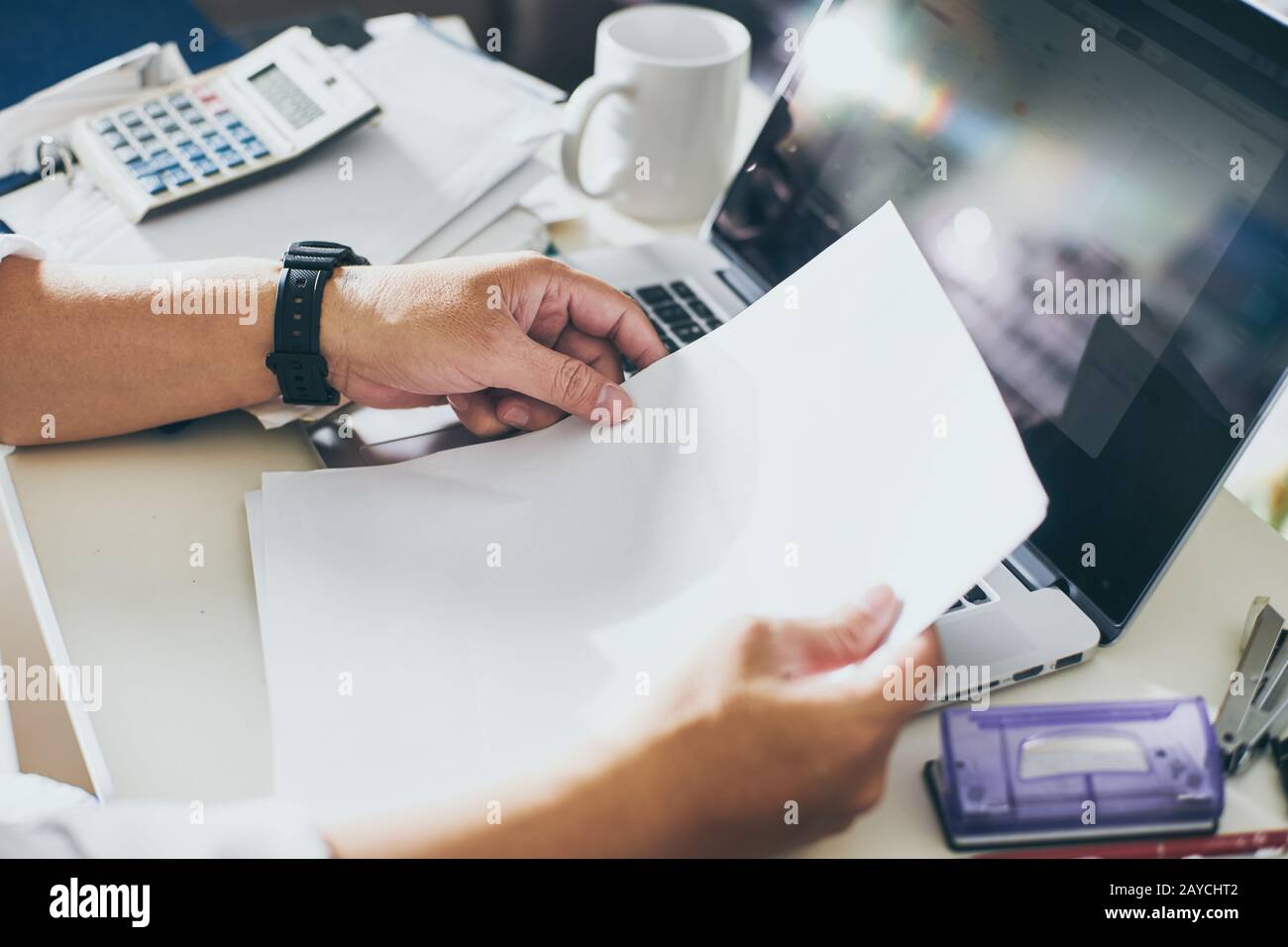 Hands of businessman holding blank paper with laptop and calculator. Accounting. Stock Photo