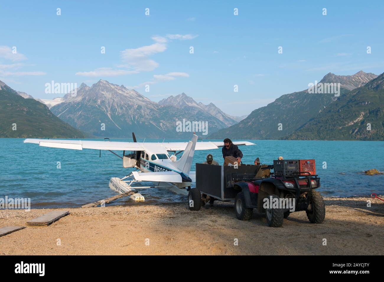 A seaplane is being unloaded at the Redoubt Mountain Lodge on Lake