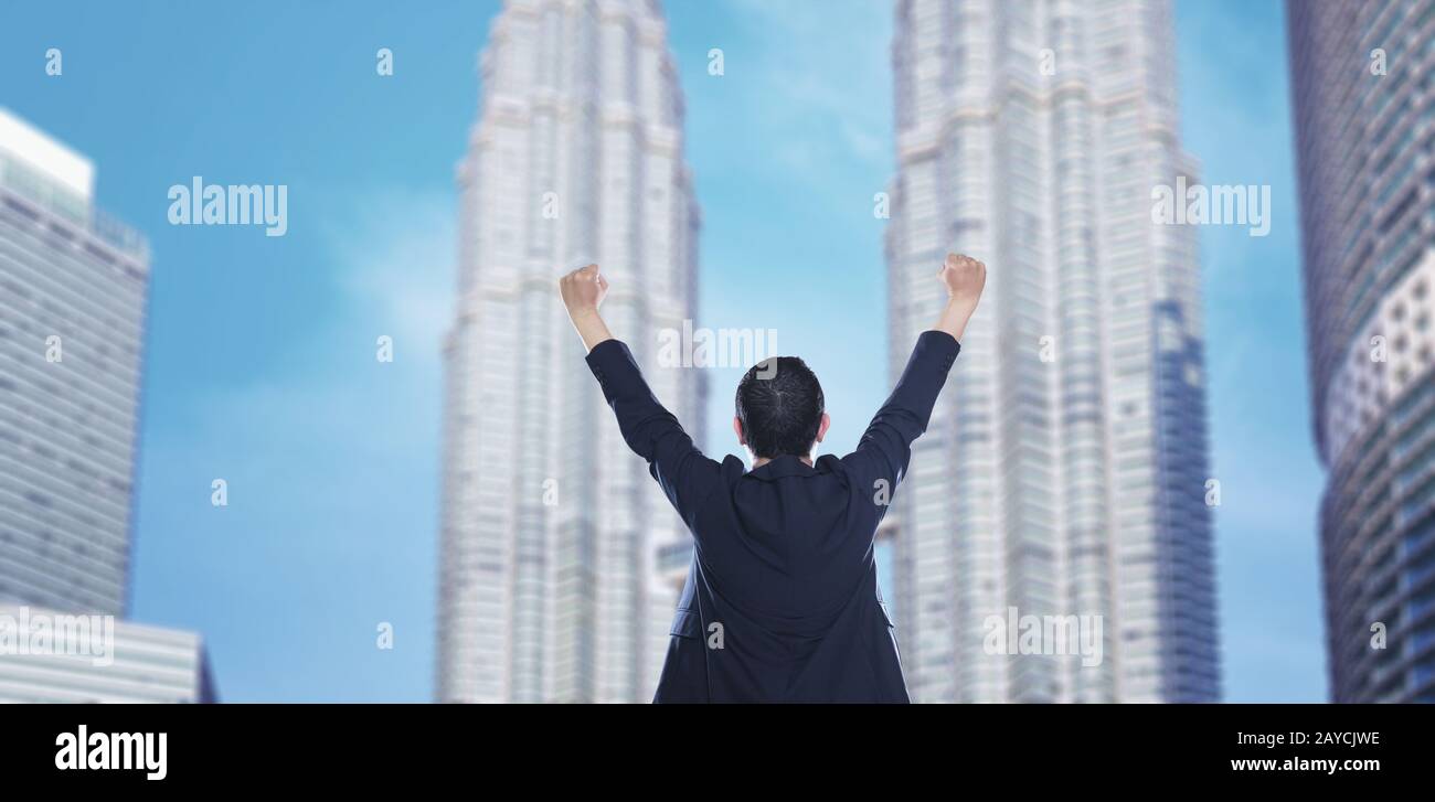 Business success - Celebrating business man overlooking the city center high-rises. Stock Photo