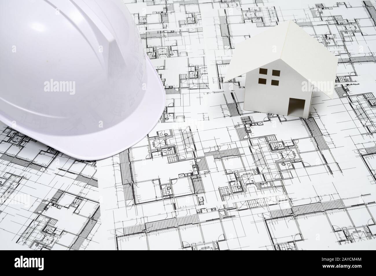 Construction industry concept with a hard hat on architectural drawing. Stock Photo