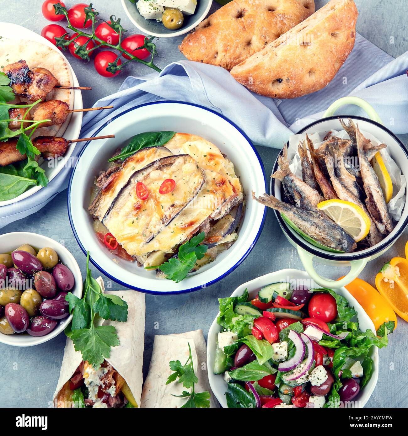 Greek food on grey background. Moussaka, gyros,souvlaki, pita, salad, olives and vegetables
