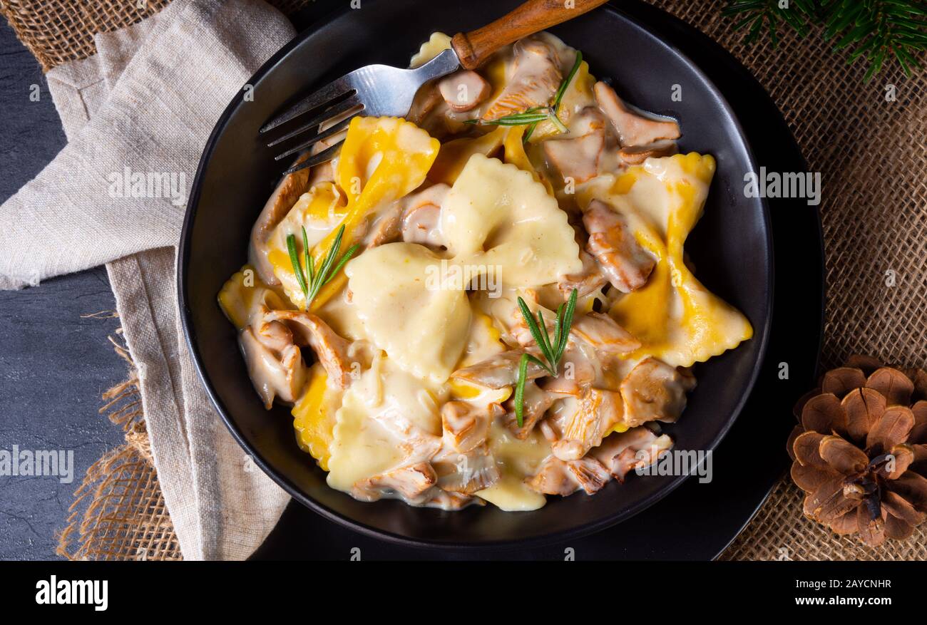 Colorful farfalle pasta with chanterelles and cream sauce Stock Photo