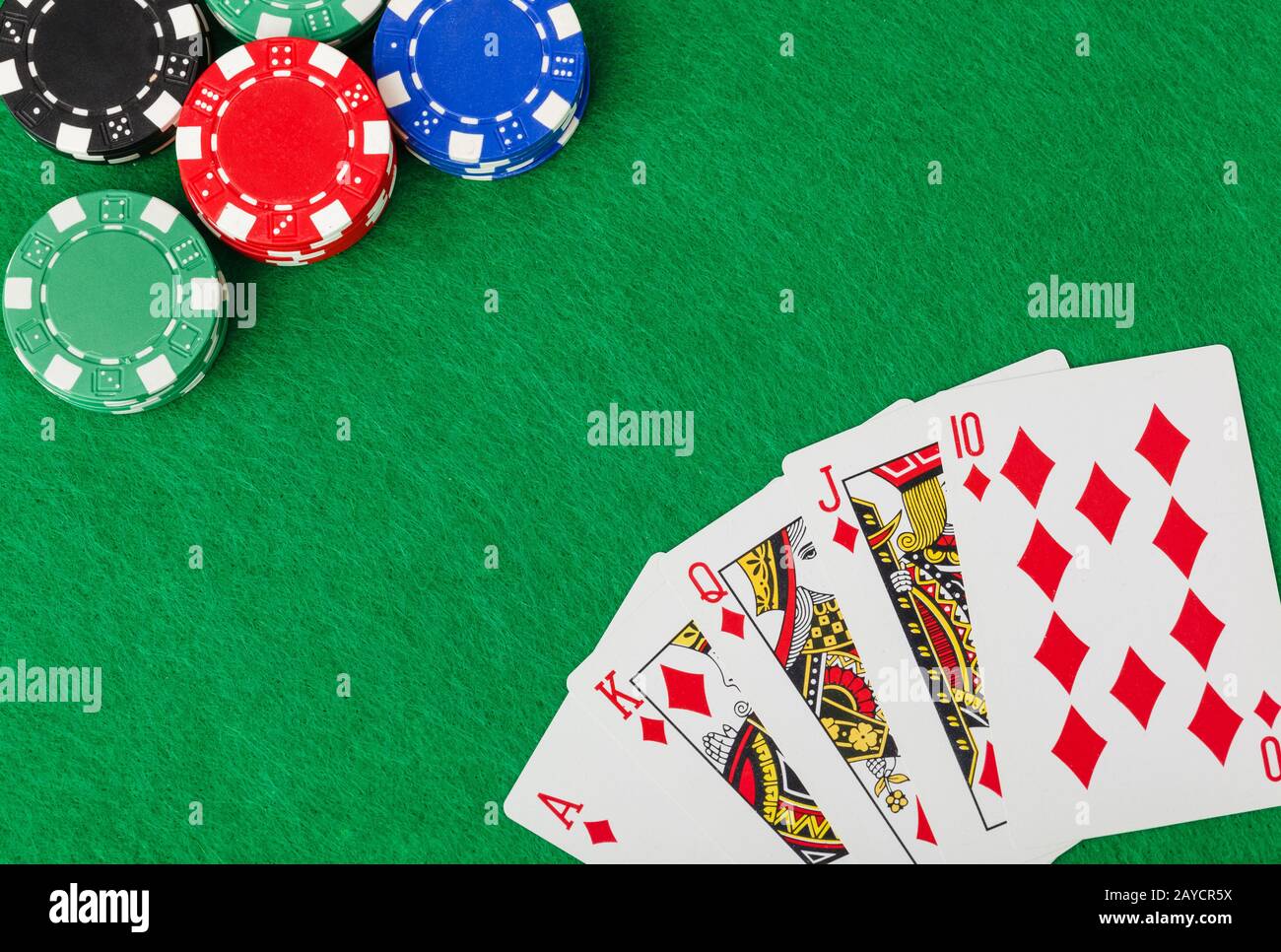 Casino chips and playing cards on green table Stock Photo