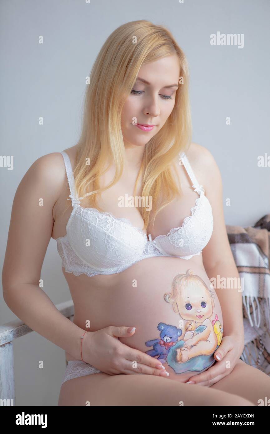 Happy pregnant woman with a beautiful drawing on her stomach Stock Photo