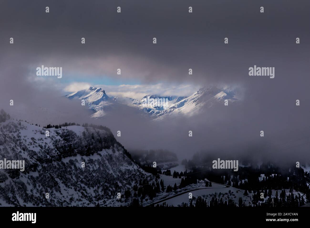 Vista between clouds on sunlit mountains Stock Photo