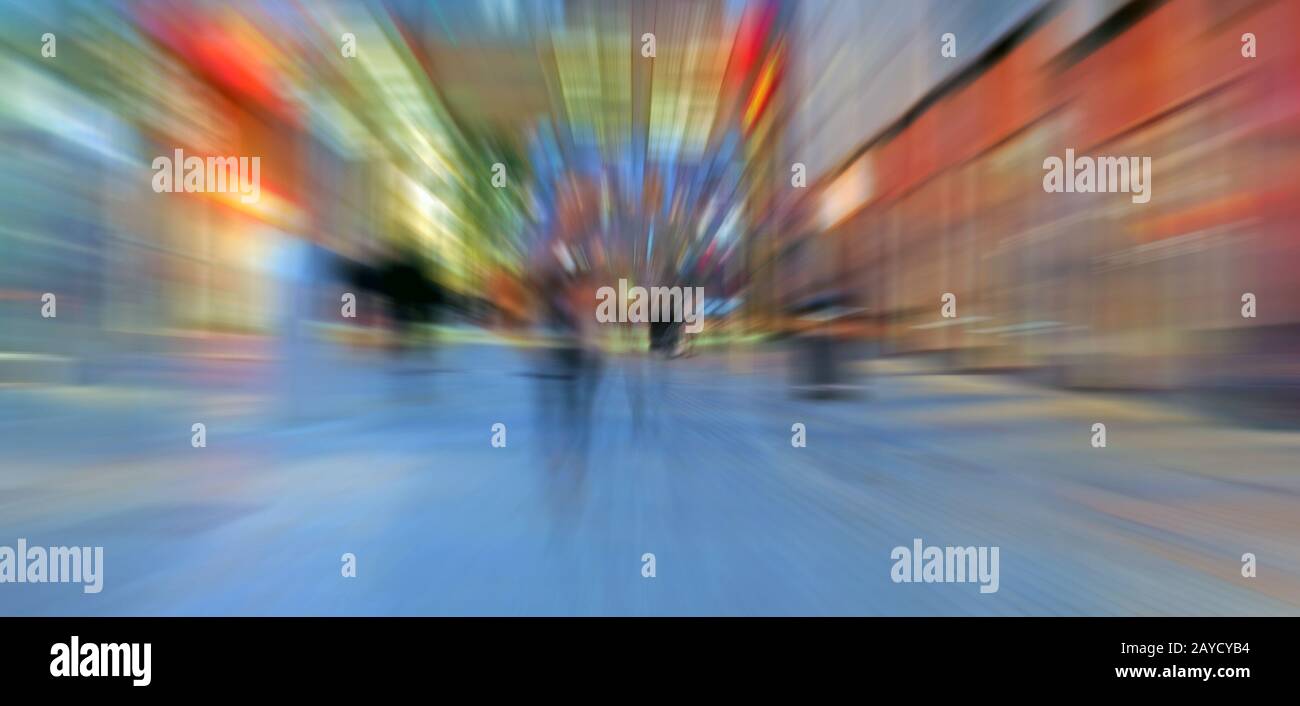 abstract zoom blur of a modern city street at night with people walking ...