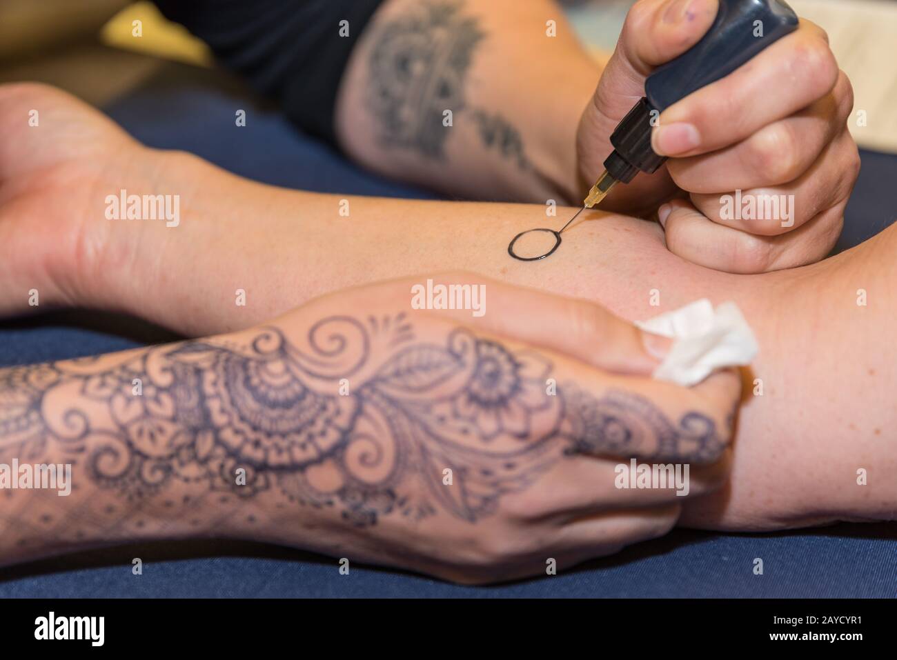 Person makes henna tattoo on his arm - Mehndi Stock Photo