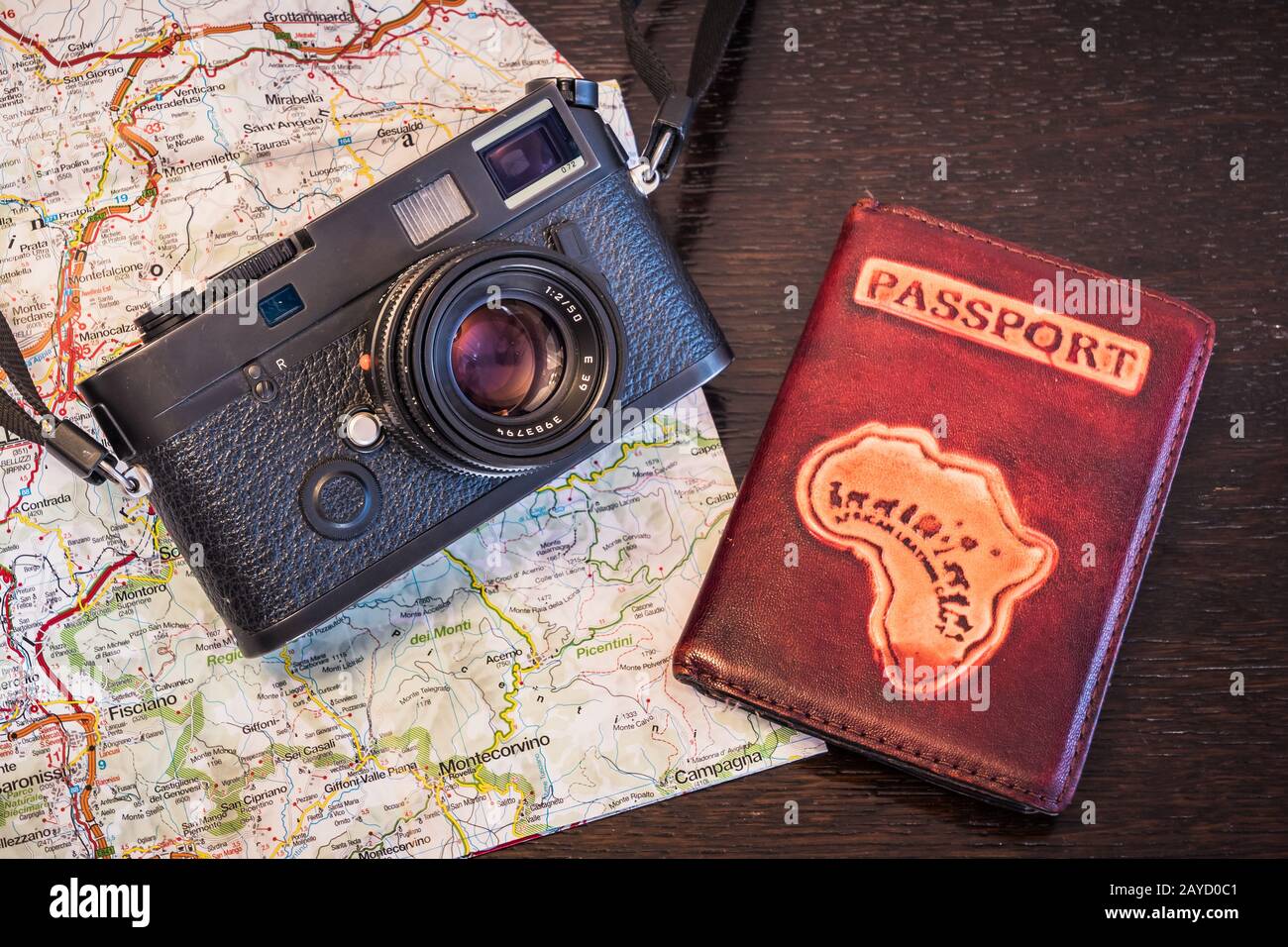 Travel Photography Concept - Black, Retro, Vintage Photo Camera, Passport and Map on a Dark Wood Background - Vintage Look Stock Photo