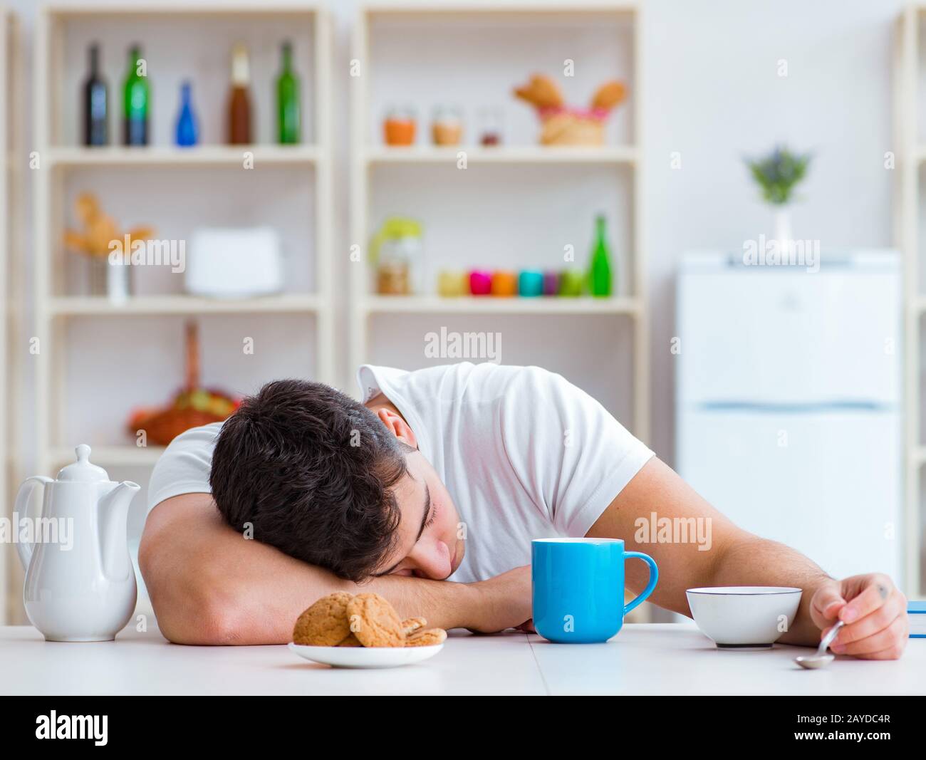 Man falling asleep during his breakfast after overtime work Stock Photo