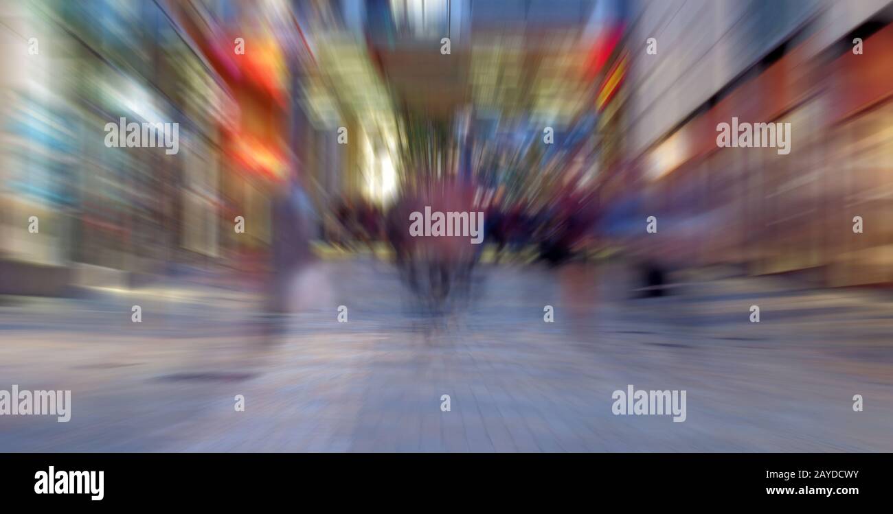 abstract zoom blur of a modern city street at night with people walking ...
