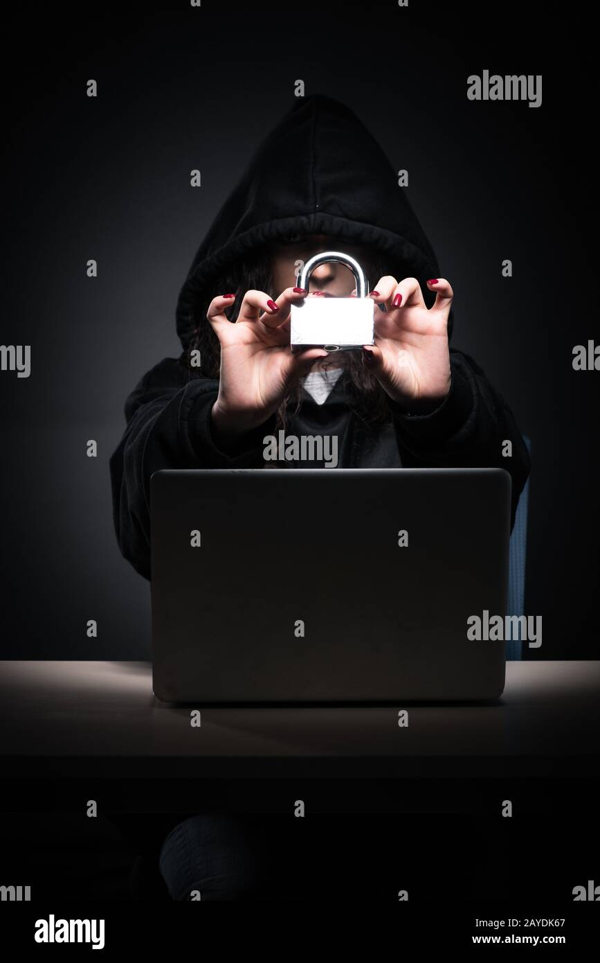 Female hacker hacking security firewall late in office Stock Photo