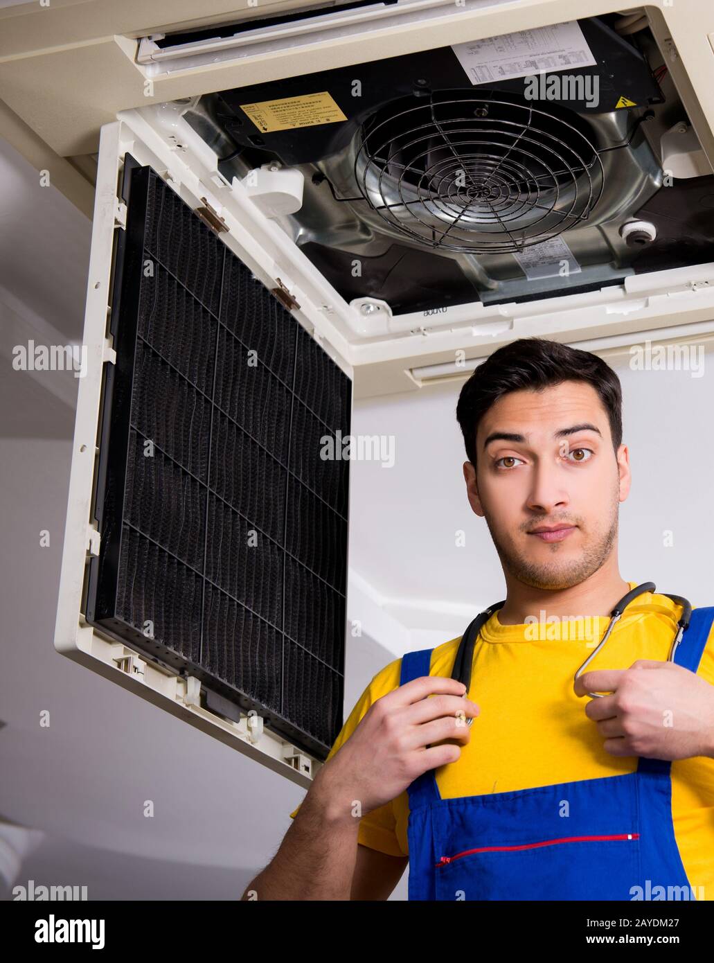 Repairman repairing ceiling air conditioning unit Stock Photo Alamy